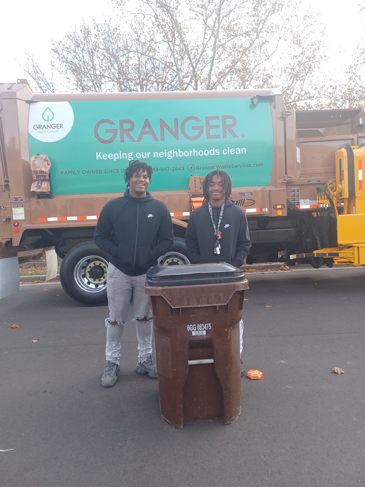 Two students pose with trash bin and Granger Trash Truck, November 4th, 2022