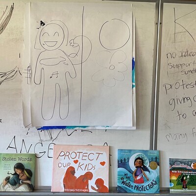 Drawings on a whiteboard above 4 books